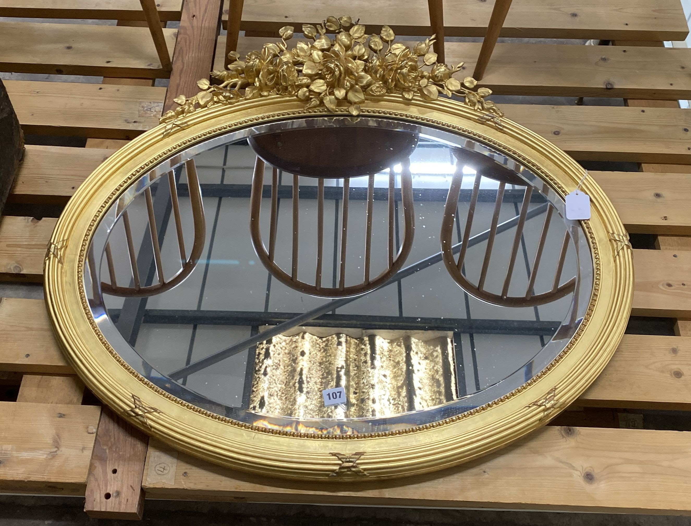 A late Victorian oval giltwood and gesso wall mirror, width 90cm, height 82cm